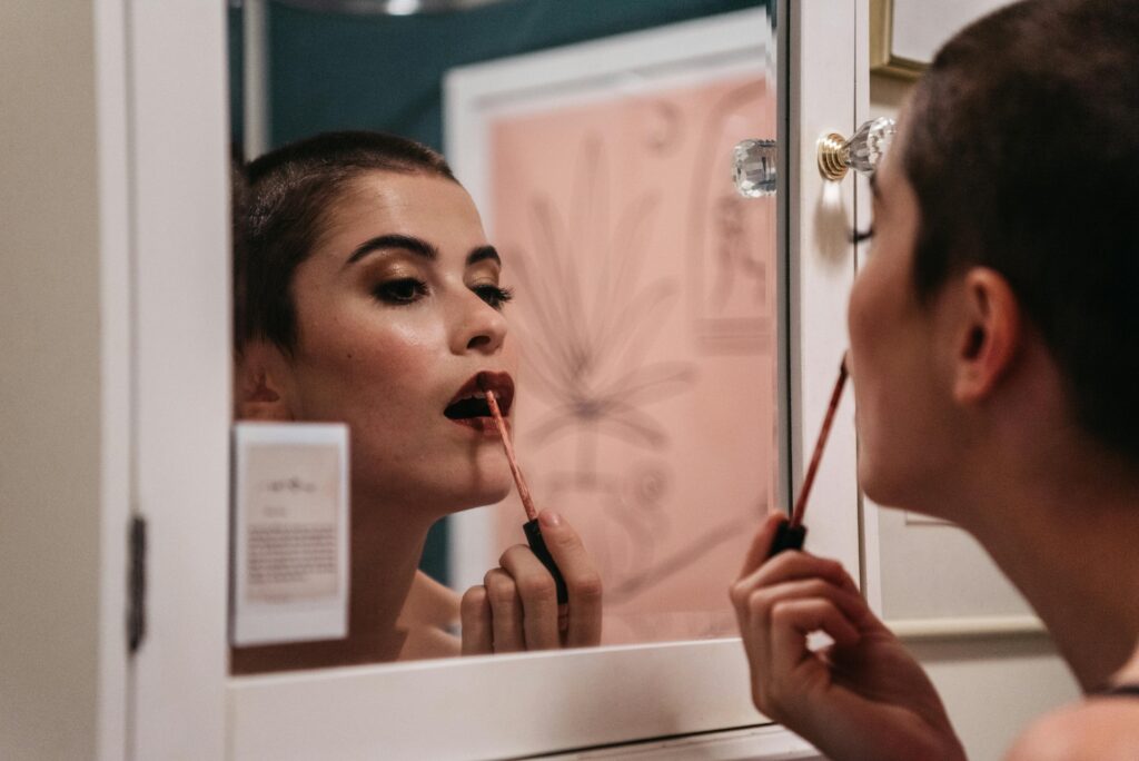 a woman putting on lipsticks of mvcosmeticx